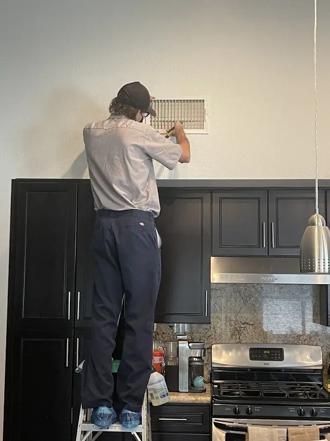 Technician inspecting an air vent during HVAC service in Port Royal
